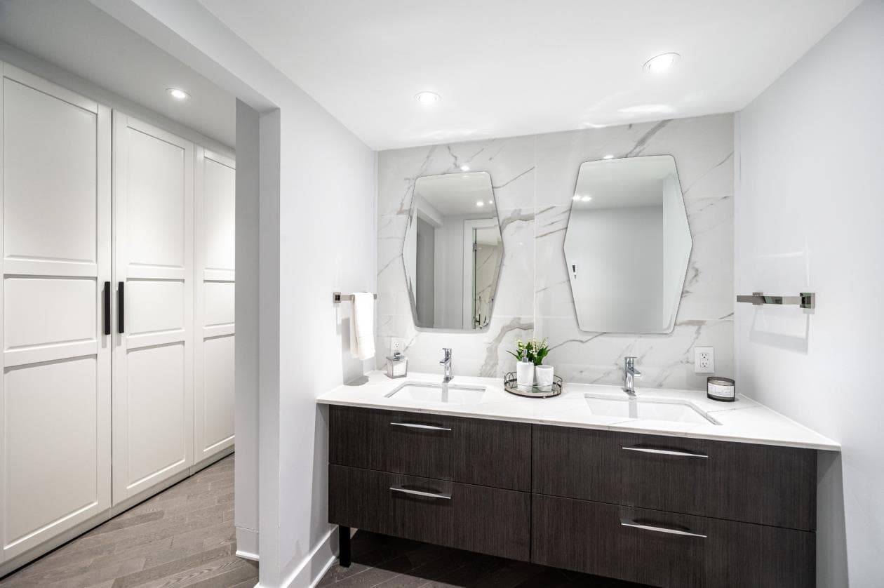 Vanité double lavabo en bois foncé avec mur en calacatta et miroirs hexagonaux
