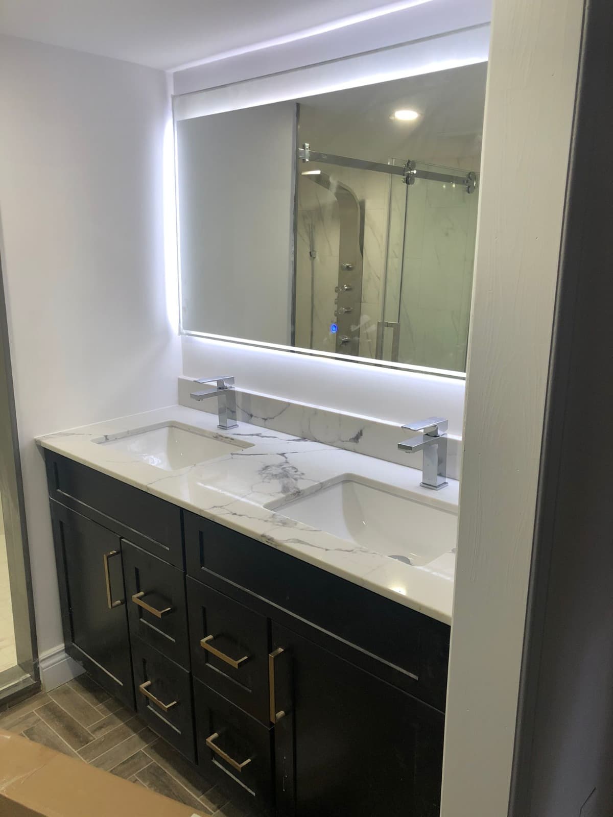 Vanité double lavabo en bois foncé avec comptoir calacatta et miroir rétroéclairé