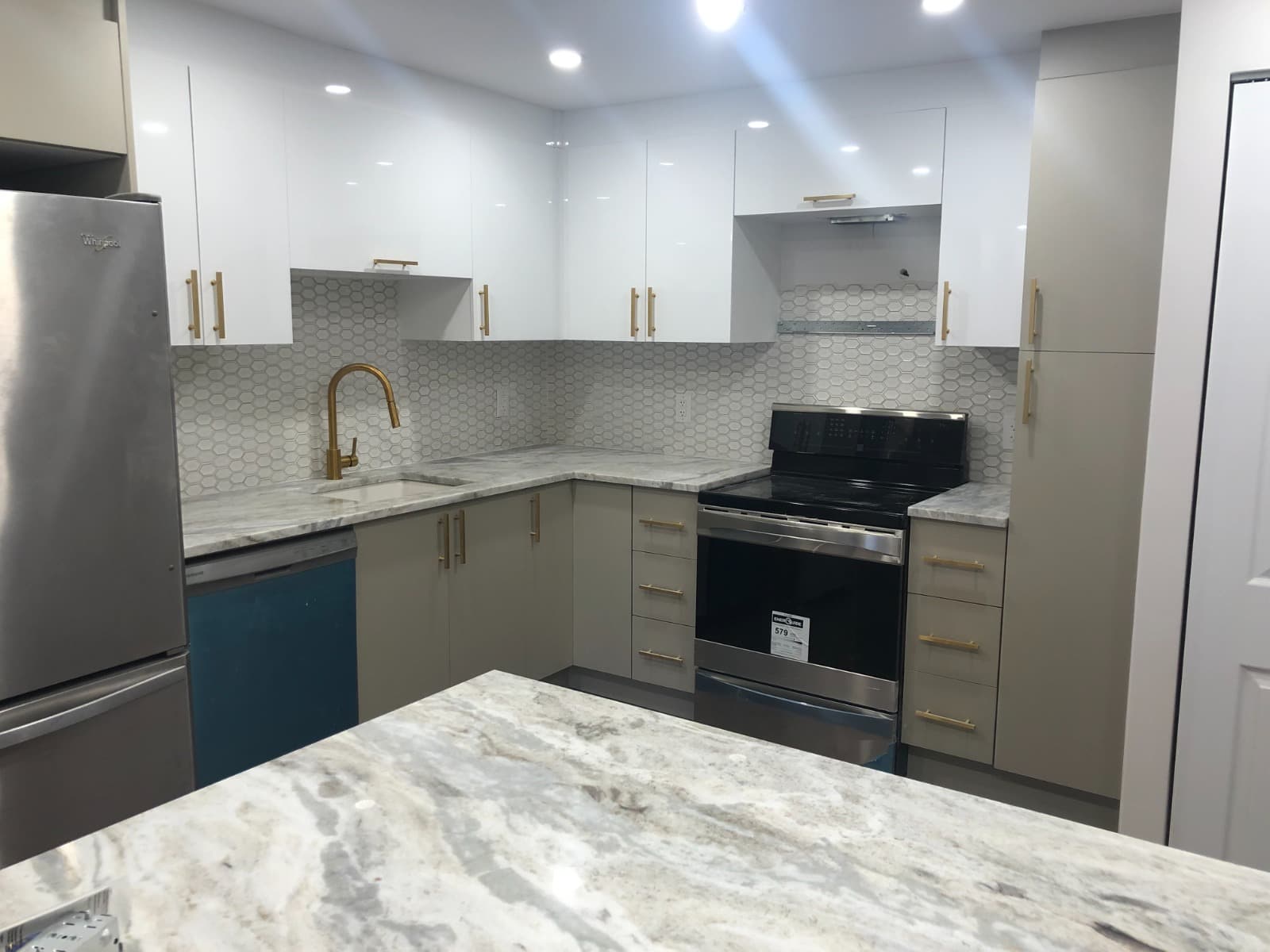 Cuisine bicolore lin et blanc avec carrelage hexagonal et robinetterie laiton